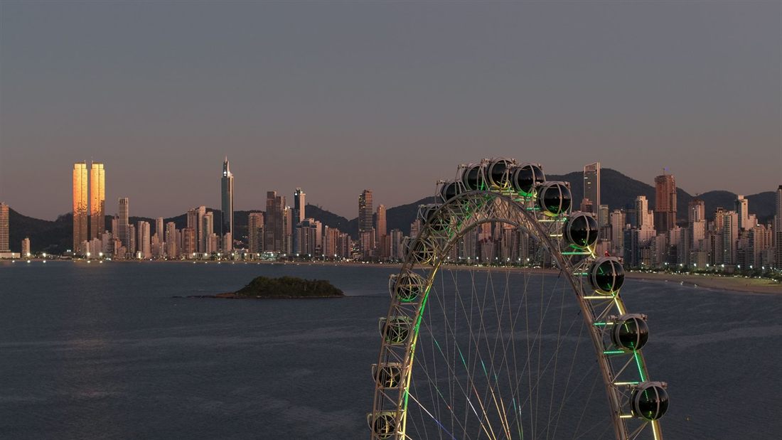 The bay of Balneário Camboriú at twilight, with the lit Ferris wheel in front of the high-rise skyline