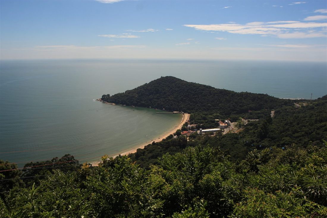 Laranjeiras beach, a small curved cove between forested hills, seen from the Unipraias lookout