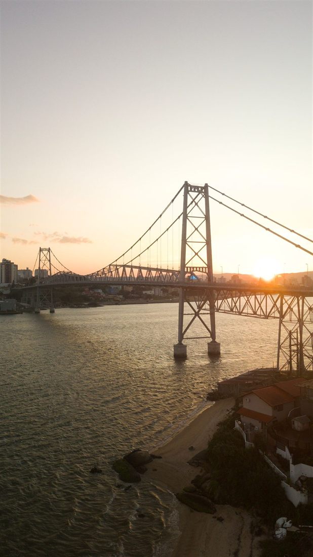 The Hercílio Luz suspension bridge in Florianópolis at sunset, seen from above the water