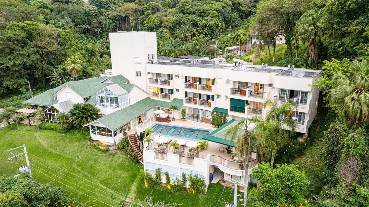 Villa do Vale Boutique Hotel from above: the building on its hill, the pool deck and the forest around it