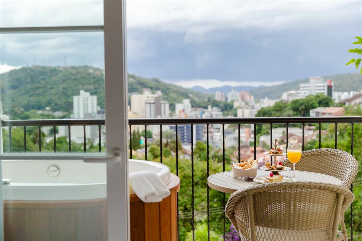 A balcony at the Villa do Vale: a tub, a small breakfast table and the city and hills below