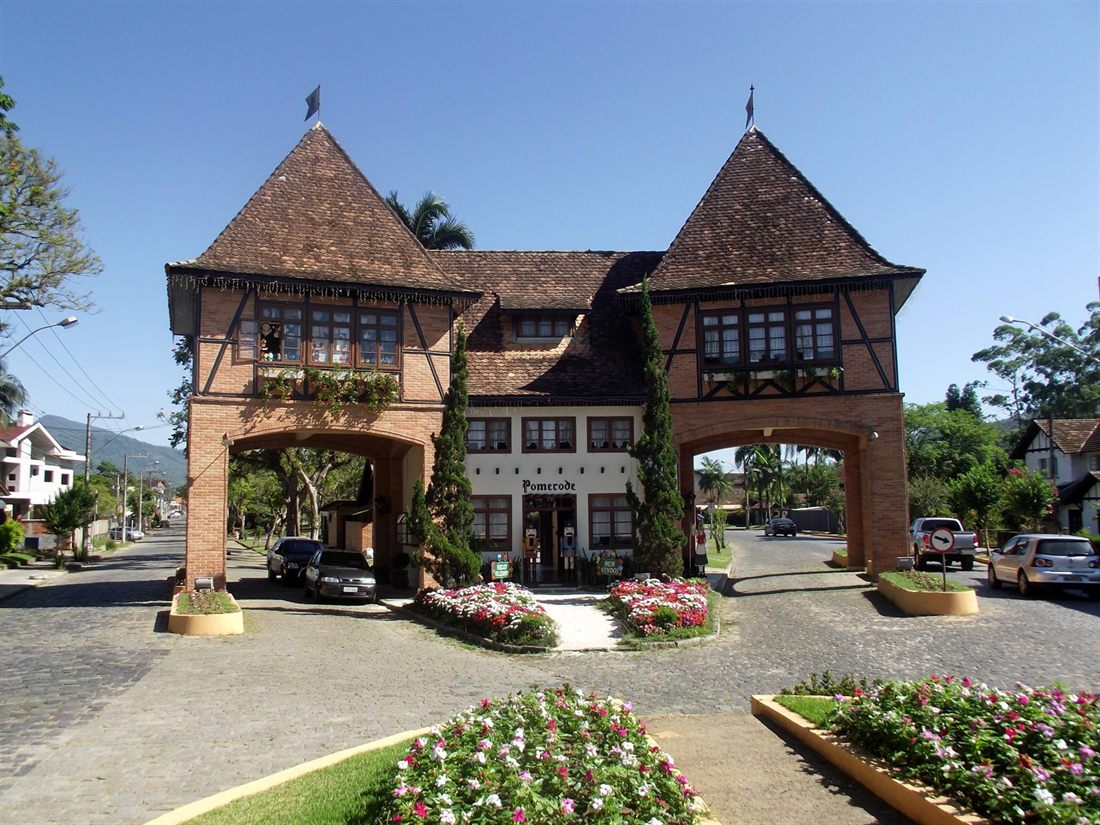 The brick-and-timber entrance portal of Pomerode, with two pointed roofs over the road
